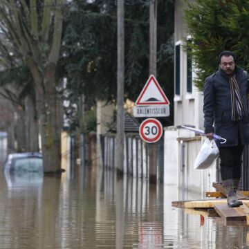 Un habitant marche sur une passerelle dans une rue inondée de Villeneuve-Saint-Georges, près de Paris, où l'Yerres est entrée en crue jeudi 25 janvier 2018. Photo AP/Thibault Camus