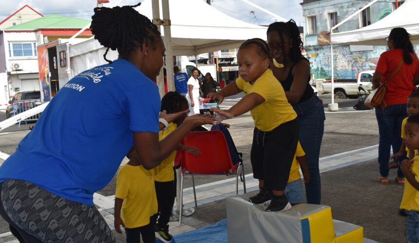 Dans l'atelier du saut dans le vide, un tout-petit expérimente l'équilibre entre peur et confiance, place Gerty Archimède, Morne-à-l’Eau, semaine de la petite enfance. Photo : Ville de Morne à l'eau